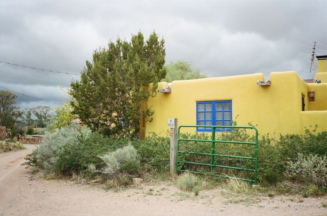 35mm film photograph of Colorful yellow Adobe house in Galisteo, New Mexico