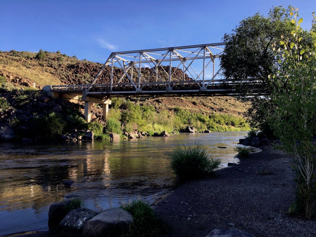 Taos Junction Bridge across the Rio Grande viewed from sandy beach in Orilla Verde Recreation Area